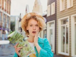 redhead young woman travel over West Europe and using paper map in unknown town. Travel photo. Lost in new city photo