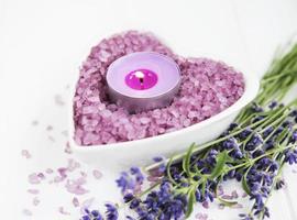 Heart-shaped bowl with sea salt, soap and fresh lavender flowers photo