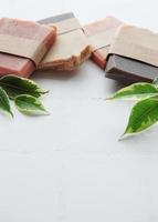 Handmade soap bars and green leaves photo