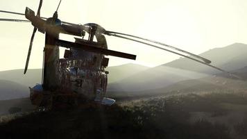 old rusted military helicopter in the desert at sunset photo