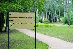 blank sign in the park by the path on the background of trees photo