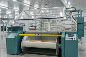 textile yarn on the wrapping machine is screwed on the big shaft. machinery and equipment in a textile factory photo
