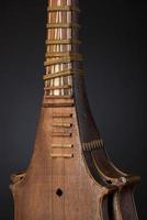 parte antiguo instrumento musical de cuerda asiático sobre fondo negro con retroiluminación foto