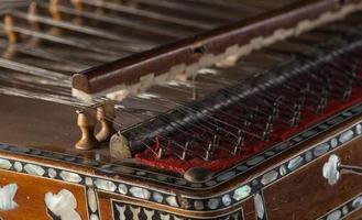 ancient Asian stringed musical instrument on black background with backlight. the similarity of the harp and psaltery. closeup photo