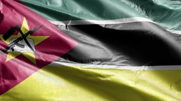 Mozambique textile flag slow waving on the wind loop. Mozambican banner smoothly swaying on the breeze. Fabric textile tissue. Full filling background. 20 seconds loop. video