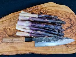 purple Asparagus officinalis a saisonal vegetable on olive wood photo