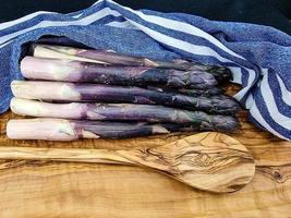 purple Asparagus officinalis a saisonal vegetable on olive wood photo