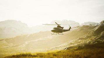 Helicóptero de la época de la guerra de vietnam en cámara lenta en las montañas foto