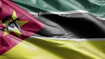 moçambique flagga långsamt viftande på vindslingan. moçambikisk banderoll svajar smidigt på vinden. full fyllning bakgrund. 20 sekunders loop. video