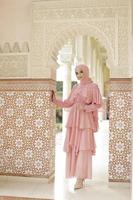 retrato de cuerpo completo de dama usa un vestido de novia, maquillaje de boda en hijab. vestido de novia malayo o indonesia, concepto de belleza o eidul fitri. hermosa mujer musulmana del sudeste asiático posando en la mezquita foto