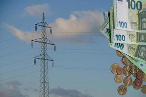 Poste eléctrico único con muchos billetes y monedas de euro en relación con el aumento de los precios de la electricidad foto