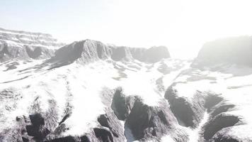 snowy mountains with deep ravine and rock cliffs photo