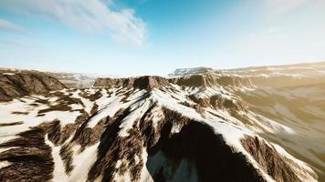 row of sharp dark cliffs standing out from the snow photo