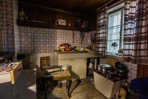kitchen in a abandoned house with lot of old objects photo