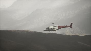 extreme slow motion vliegende helikopter in de buurt van bergen met mist video