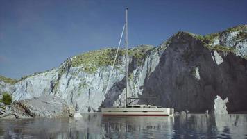 yacht dans la mer avec une île rocheuse verdoyante video