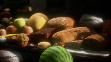 mesa de comida con barriles de vino y algunas frutas, verduras y pan