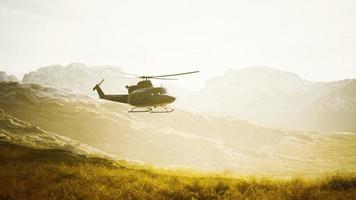 slow motion Vietnam War era helicopter in mountains photo