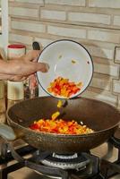 Add red and yellow bell peppers to the pan to make the dish photo