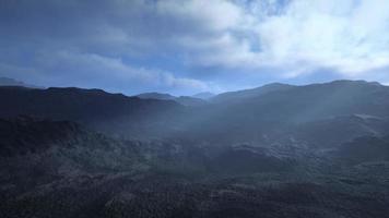 black volcanic dust and mountains with fog in background photo