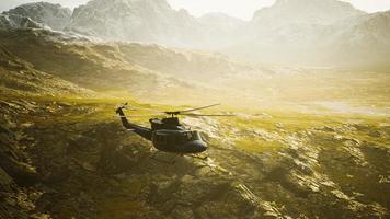 slow motion Vietnam War era helicopter in mountains photo