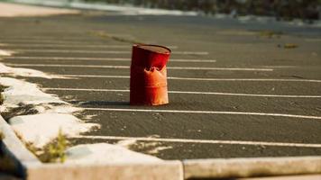 old and rusty metal barrel on parking photo