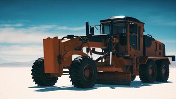 road grading machine on the salt desert road photo