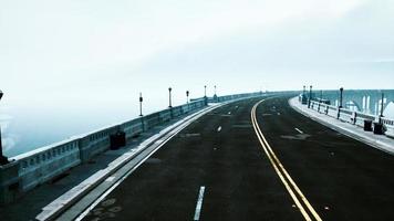puente de carretera vacío iluminado en la niebla foto