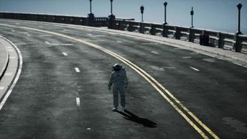 astronaut walks in the middle of a road photo