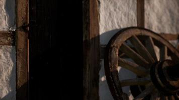 vieille roue en bois et porte noire à la maison blanche video