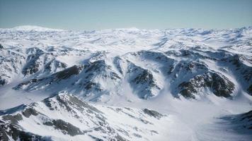 Paisaje aéreo de 8k de montañas nevadas y costas heladas en la Antártida