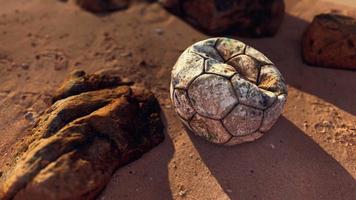 bola de futebol de couro velha abandonada na areia