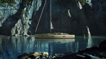 White yacht anchored in a bay with rocky cliffs video