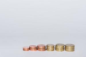 different euro coins stacked in a row increasing in value with gray photo