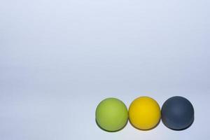 tres bolas de diferentes colores para masaje en una fila sobre fondo gris a la derecha foto