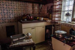 kitchen in a abanonded house with a libra and old pots photo