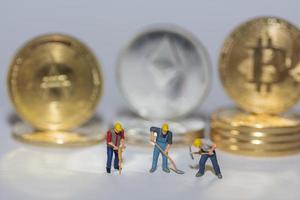 valueable crypto coins bitcoin ether and ada in a row with three worker on gray photo