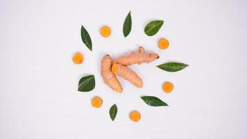 interestingly arranged pieces of turmeric and lime leaves isolated on white background photo