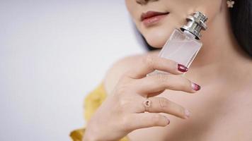 beautiful asian girl showing perfume isolated on white background photo