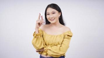 Asian girl with makeup showing lipstick in her hand isolated on white background photo