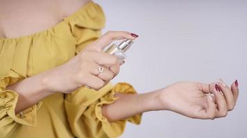 beautiful asian girl trying perfume on her hand isolated on white background photo