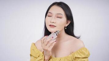 beautiful asian girl showing perfume isolated on white background photo