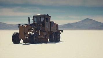 road grading machine on the salt desert road photo