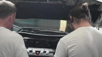 mechaniker-techniker-team-person repariert automotoren, motorautoservice und professionelle wartungsprüfung in der garage, im autofahrzeug oder in der automaschinenbesetzung video