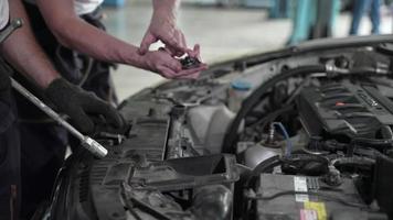 monteur technicus teampersoon repareert automotor, motor-autoservice en professionele controle van onderhoud in garage, autovoertuig of auto-machinebezetting video