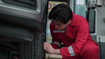 servizio di officina del tecnico, cambio meccanico di pneumatici e ruote per auto nel garage dell'automobile, manutenzione del trasporto di veicoli e strumento di riparazione auto, occupazione di persone con pneumatici al lavoro video