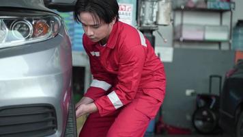 service d'atelier de technicien, mécanicien changer le pneu et la roue de voiture dans le garage automobile, outil d'entretien et de réparation automobile pour le transport de véhicules, occupation de l'homme avec pneu au travail video