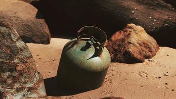 old cooking gas cylinder on sand beach photo