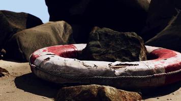 viejo aro salvavidas roto en la playa del mar foto