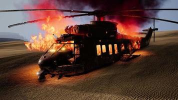 Hélicoptère militaire brûlé dans le désert au coucher du soleil